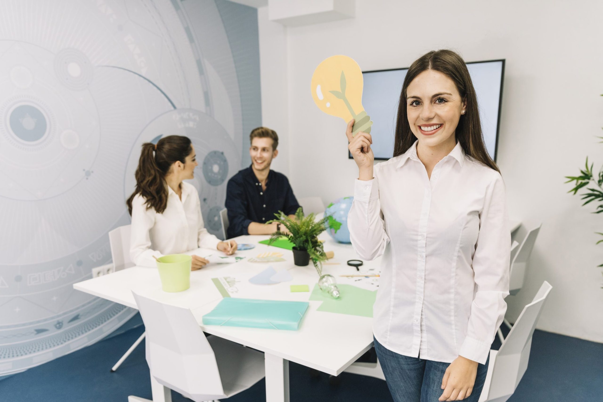 portrait-smiling-young-businesswoman-with-light-bulb-icon-standing-office